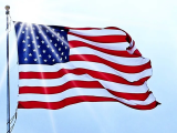 American Flag with sun shining behind it